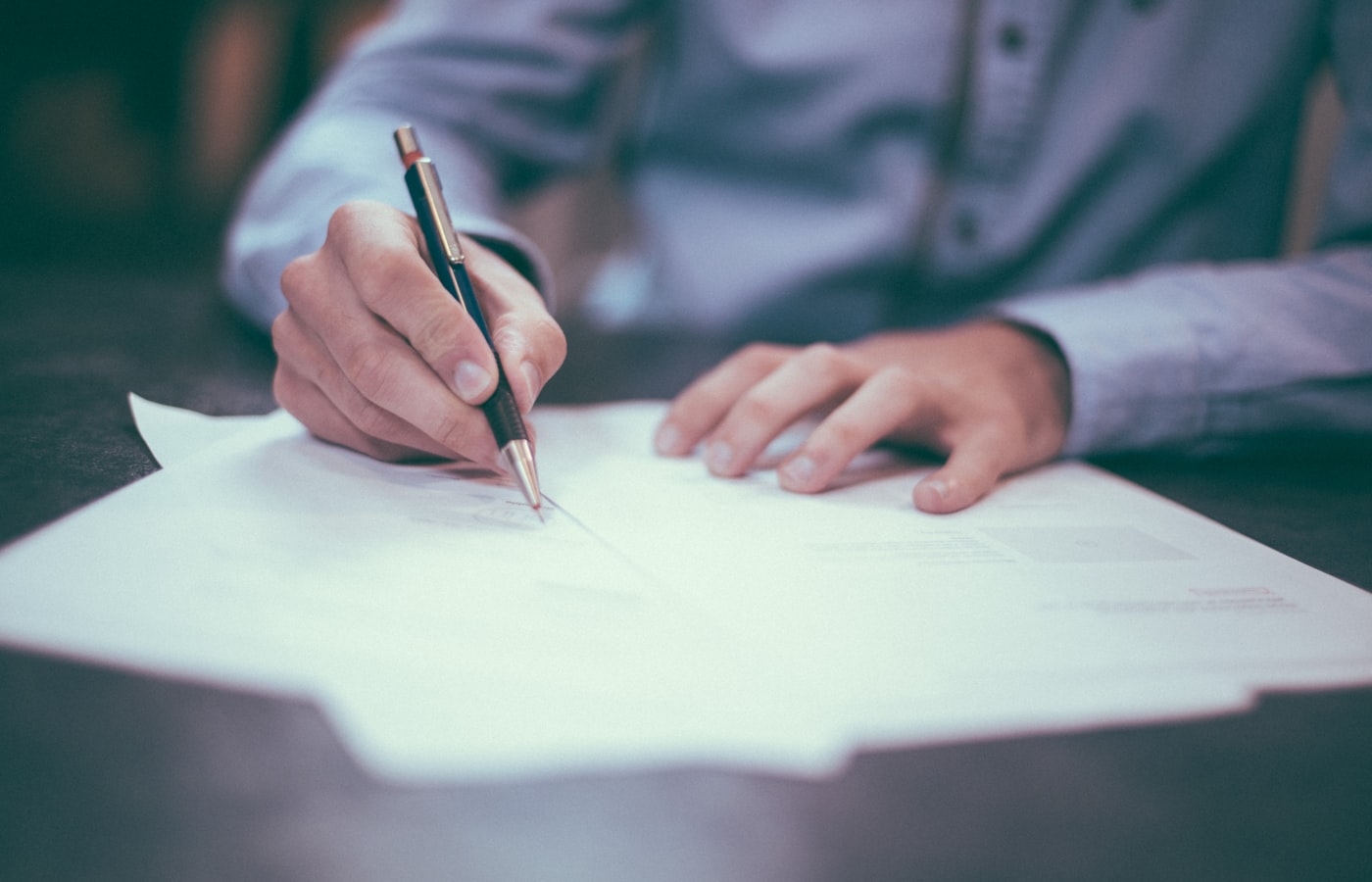 Business documents and a pen on a timber desk