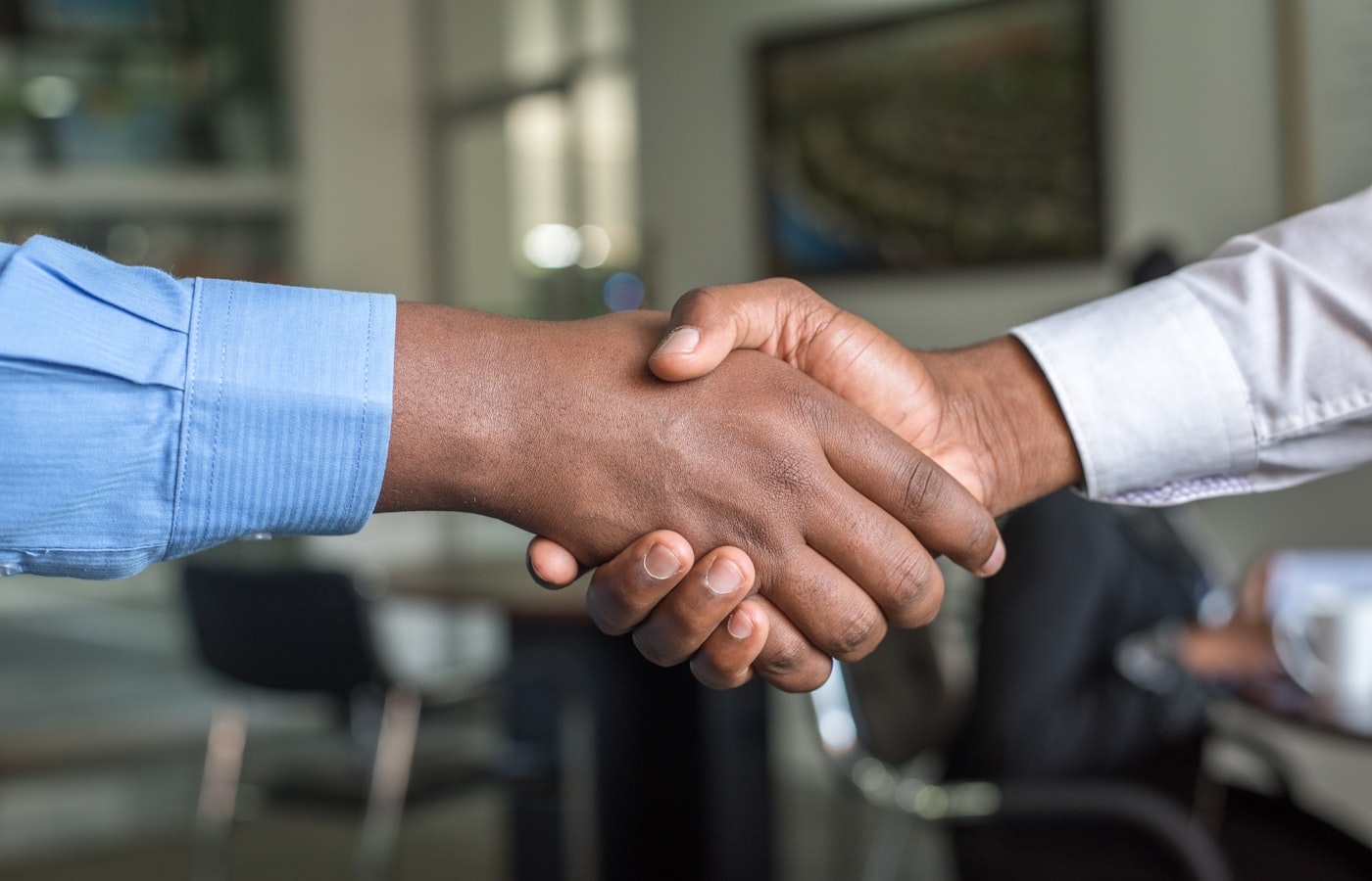 Handshake across a meeting table during a business handover